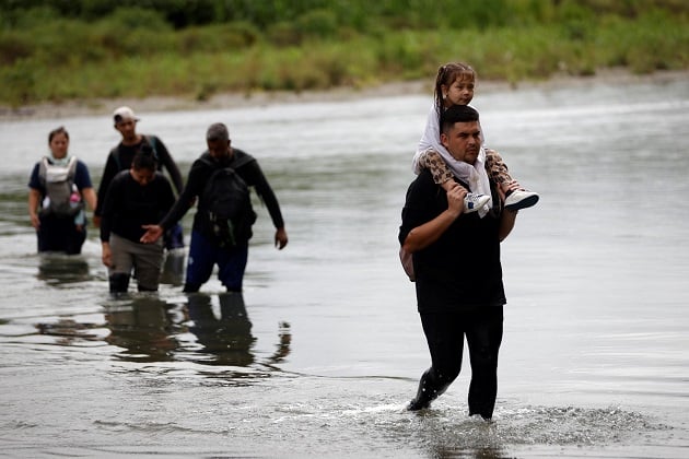 Migrantes cruzan el río Tuquesa luego de atravesar la selva del Darién, en el Darien (Panamá). EFE/ Bienvenido Velasco