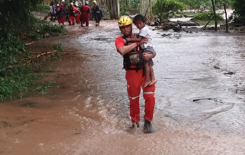 Personal de Sinaproc ayuda a un grupo de personas a salir de un área inundable. Foto. Sinaproc