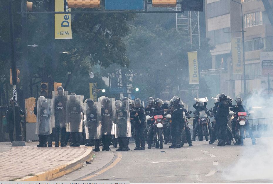 Integrantes de la Policía Nacional Bolivariana (PNB) enfrentan a manifestantes opositores. Foto: EFE