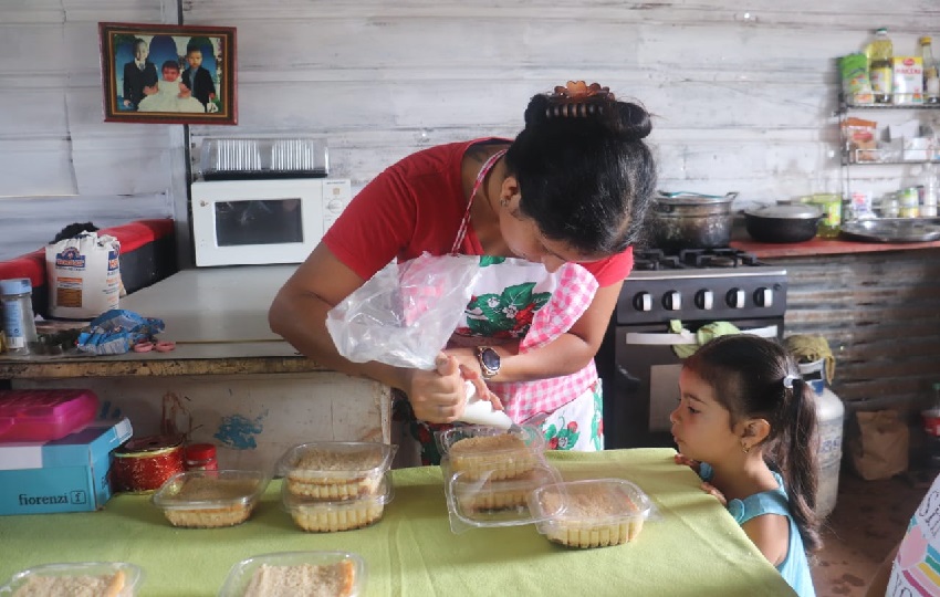 Mientras Orieli Figueroa mientras realiza sus labores de repostería supervisa la tarea de su hija. Foto. Mides