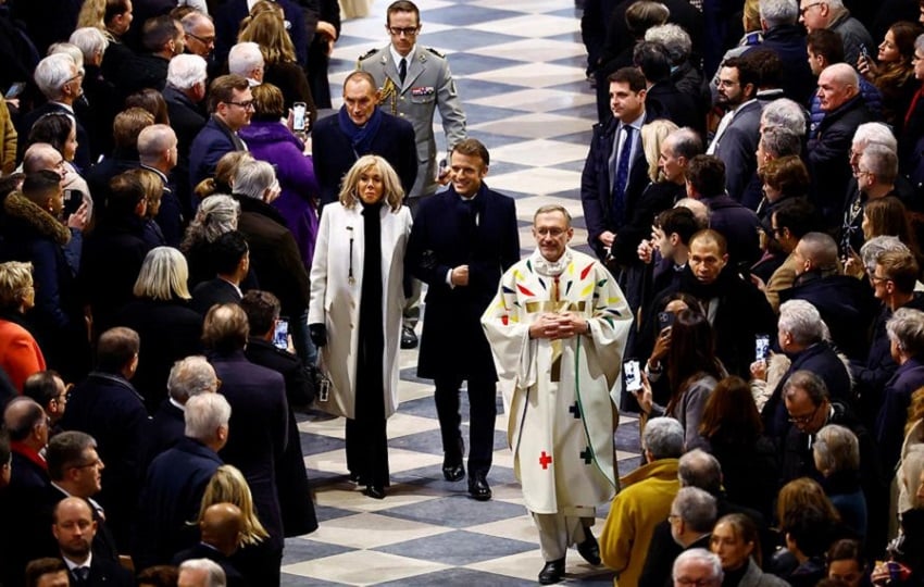 El presidente francés, Emmanuel Macron (D), y su esposa, Brigitte, llegan para asistir a la Misa inaugural, con la consagración del altar mayor, en la Catedral de Notre-Dame de París. Foto: EFE