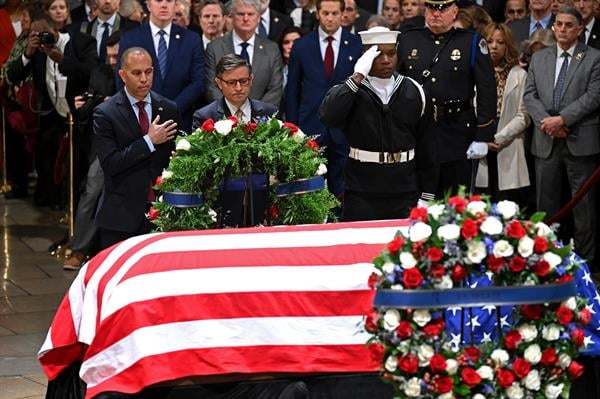 El líder de la minoría en la Cámara, Hakeem Jeffries (I), y el presidente de la Cámara, Mike Johnson, presentan una corona en nombre del Poder Legislativo en la ceremonia de capilla ardiente.