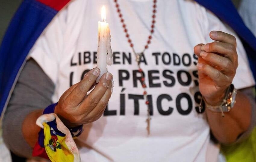 Una mujer que sostiene una vela durante una vigilia por los 'presos políticos' en la Universidad Central de Venezuela. Foto: EFE/Archivo