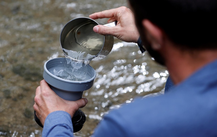 Un investigador sostiene muestras tomadas en el entorno de un río para detectar microplásticos. Foto: EFE