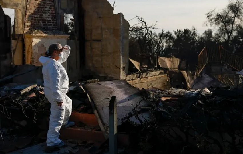 Vista de una mujer que revisa los escombros que dejó un incendio cerca de Los Ángeles en la casa de su hermana, el 21 de enero de 2025. EFE/Caroline Brehman