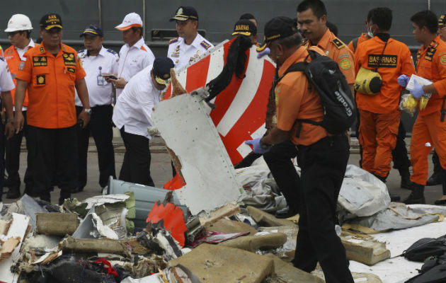 Un rescatista inspecciona una parte del vuelo recuperado de las aguas en Indonesia. AP