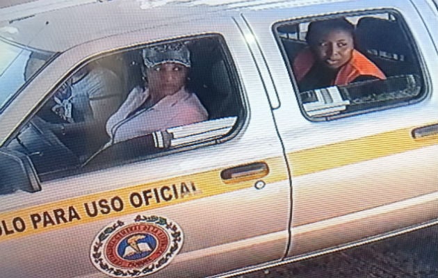 Imagen de la funcionarias vistas tomando fotos fuera de la residencia de Yanibel Ábrego.